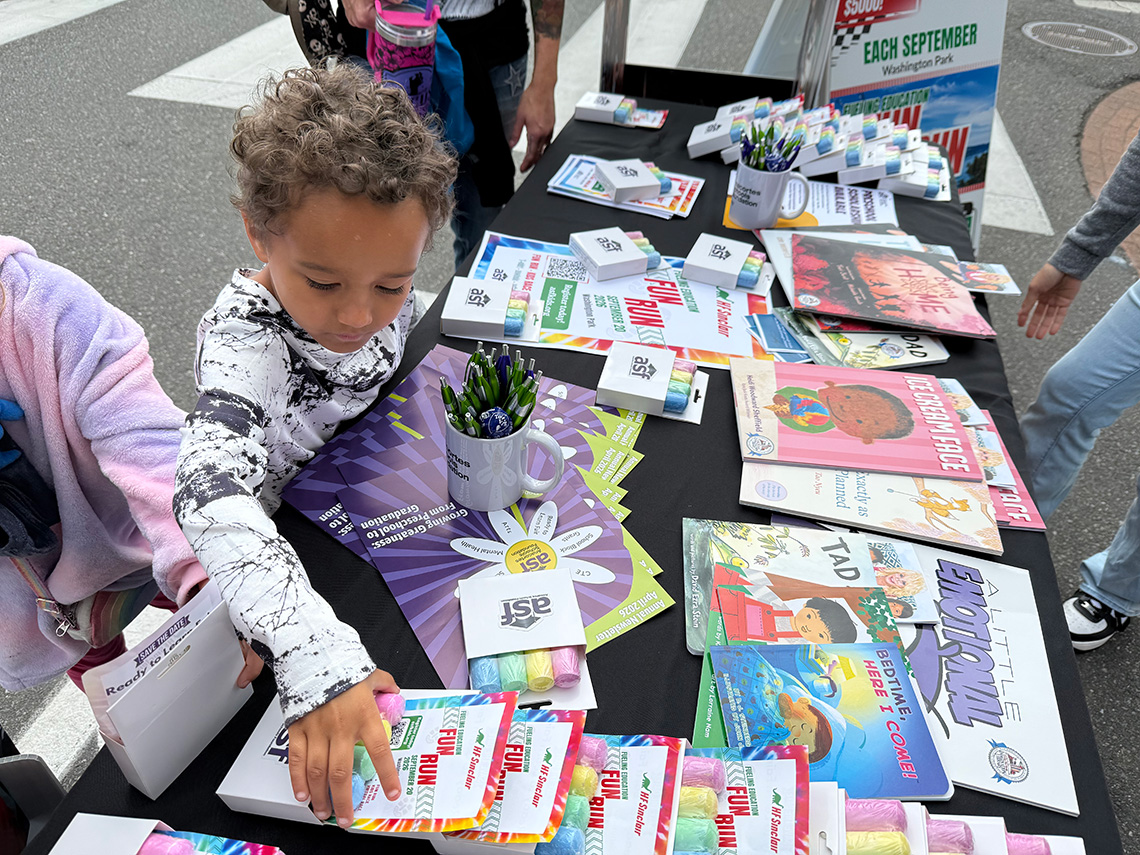 A young student selects a giveaway at the Anacortes Schools Foundation table at Open Streets 2026. A young student selects a giveaway at the Anacortes Schools Foundation table at Open Streets 2026.