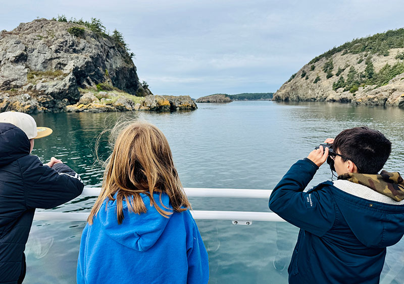 Three students observe wildlife with the Salish Sea School trip aboard Island Adventures, sponsored by Anacortes Schools Foundation.
